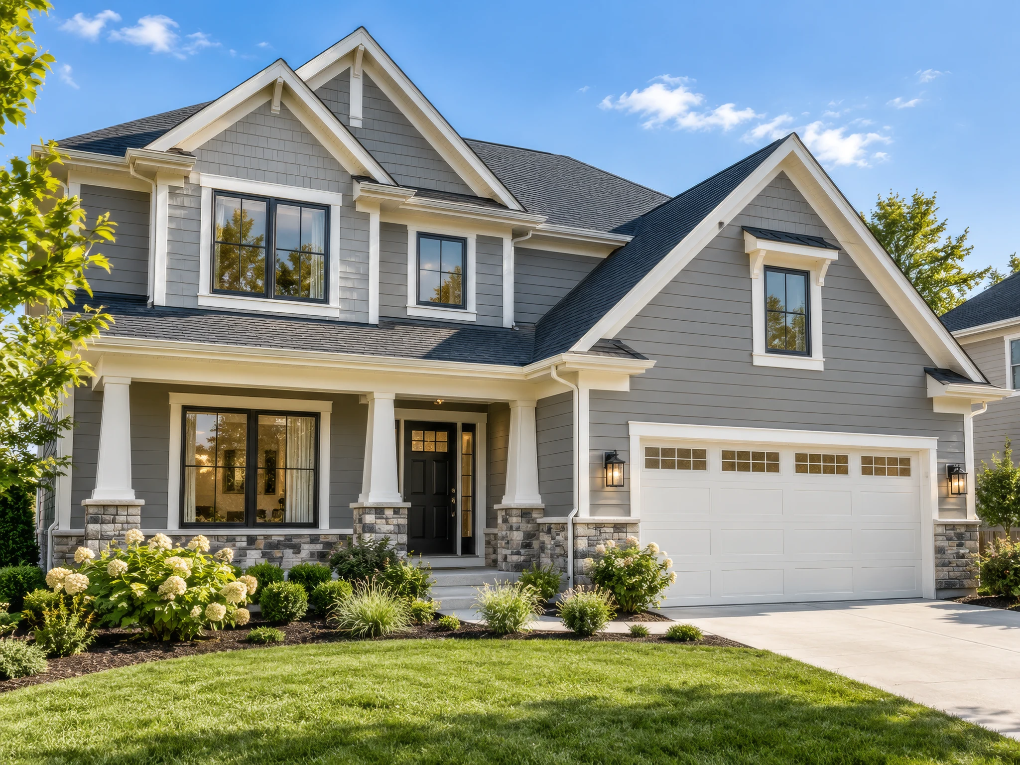 Gray Craftsman home with white siding trim, a landscaped front porch and an attached garage